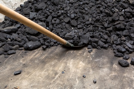 Black coal lying and shovel on a pile in house basement. Fuel material.の写真素材
