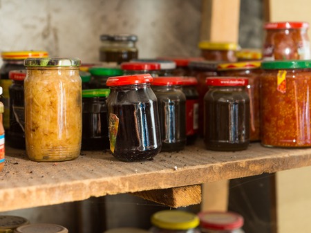 Preserves in jars in home basement. Close up of stocks kept for the winter.の写真素材