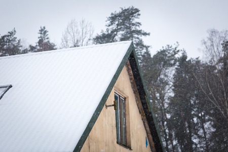 House roof with snow. Wintertime building in close up.の写真素材