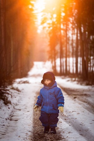 Happy little boy playing outdoor in winter snow. Snowy weather and caucasian child.の写真素材
