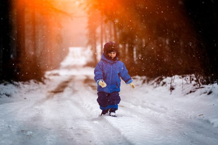 Happy little boy playing outdoor in winter snow. Snowy weather and caucasian child.の写真素材