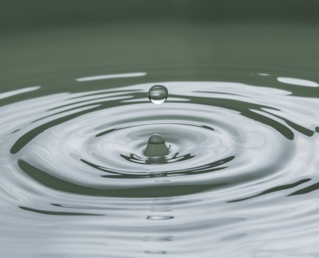 Close up of splashing droplet and water surface. Abstract background.の写真素材