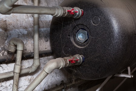 Hydraulic pipes an valves in basement. Home heating system in close up.