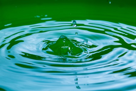 Close up of splashing droplet and water surface. Abstract background.の写真素材