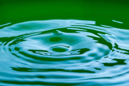 Close up of splashing droplet and water surface. Abstract background.の写真素材