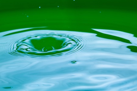 Close up of splashing droplet and water surface. Abstract background.の写真素材