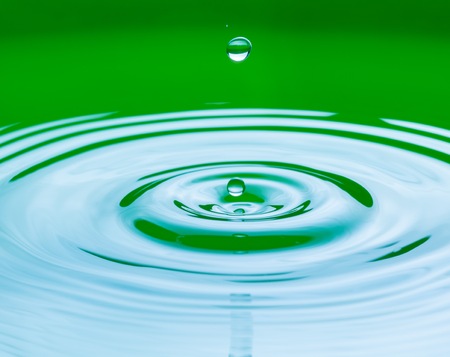 Close up of splashing droplet and water surface. Abstract background.の写真素材