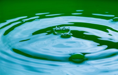 Close up of splashing droplet and water surface. Abstract background.の写真素材