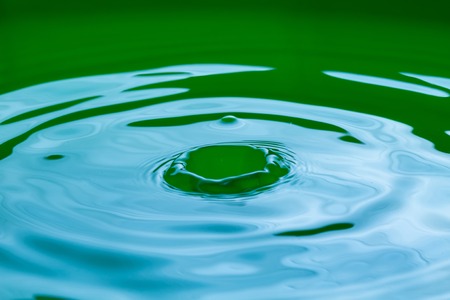 Close up of splashing droplet and water surface. Abstract background.の写真素材