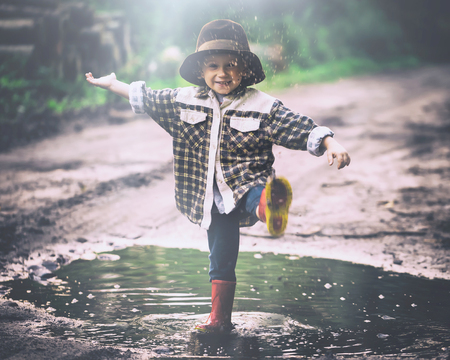Small boy playing outdoor in summer forest. 3 years old boy in hat playing in nature.の写真素材