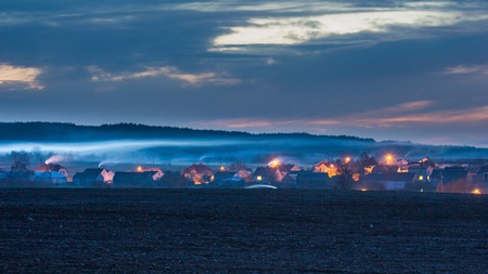 Sunset colorful sky over polish village in spring - spectacular landscape. High smog pollution from the chimneys of housesの写真素材