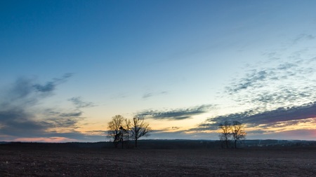 Beautiful colorful sunset sky over plowed field in springtime. Calm polish landscape. Countryside landscape.の写真素材
