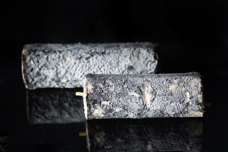 Studio shot of french goat cheese Saint Maure. Luxury food.の写真素材