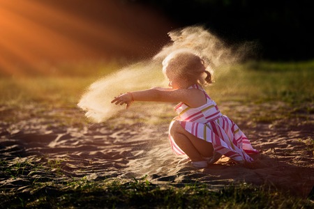 Little girl playing outdoor. Beautiful 2 years old girl.の写真素材