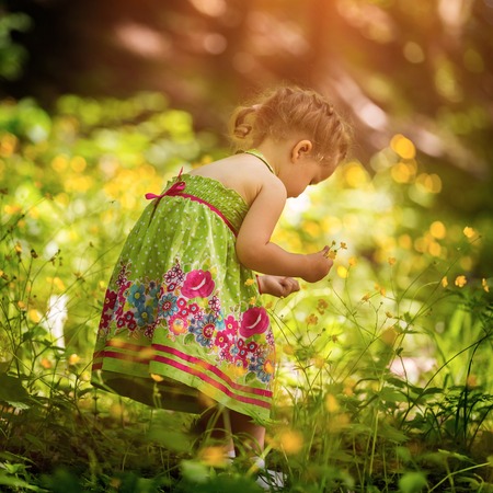 Little girl playing outdoor. Beautiful 2 years old girl.の写真素材