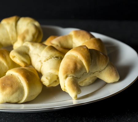 Fresh baked yeast croissants on dark background. Tasty homemade cakes.の写真素材