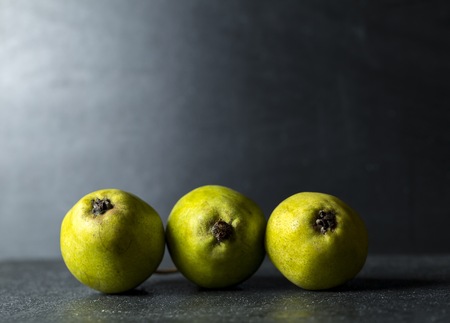 Green pears lying on dark background. Fresh fruits on dark backdrop.の写真素材