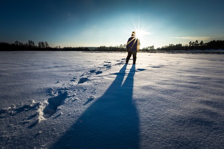 Man silhouette in tranquil winter landscape. Surreal landscape with human,の写真素材