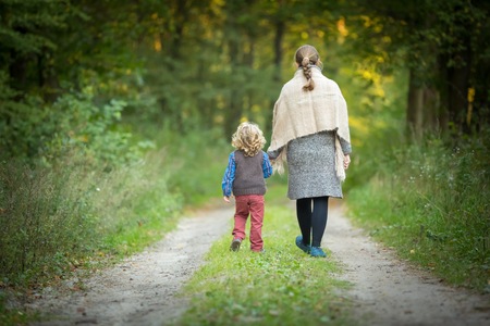 Mother and son together in forest. Family in autumnal forest.の写真素材