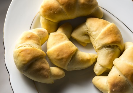 Fresh baked yeast croissants on dark background. Tasty homemade cakes.の写真素材