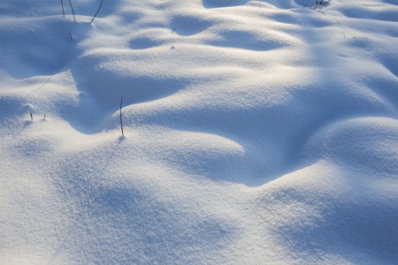 Beautiful snow patterns illuminated with golden sunset light. Winter background.の写真素材