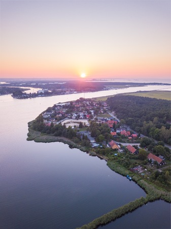 Beautiful sunset over estuary of Vistula river in Gdansk. Summer sunset over sea and river and small...