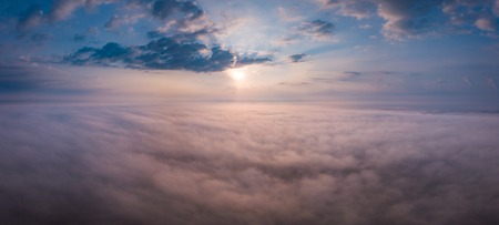 Beautiful foggy sunrise panoramic landscape from drone. Magical sunrise over the clouds.の写真素材