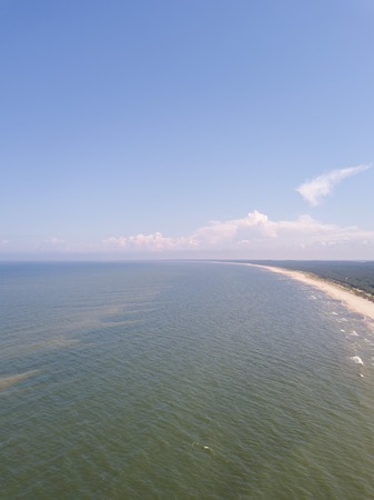 Baltic beach from above. Drone photography with sandy shore and waves of sea.の写真素材