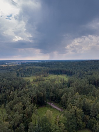 Flight over forest under cloudy sky. Drone photography, polish landscapeの写真素材
