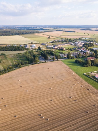 Aerial: stubble field with straw bales at late summer. Polish landscape from drone.の写真素材