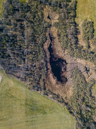 Top down aerial view with early spring meadows, pond and river. Polish landscape.の写真素材