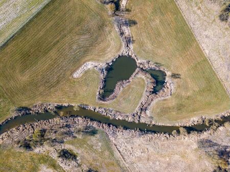 Top down aerial view with early spring meadows, pond and river. Polish landscape.の写真素材