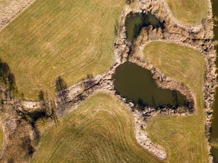 Top down aerial view with early spring meadows, pond and river. Polish landscape.の写真素材