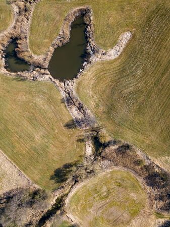 Top down aerial view with early spring meadows, pond and river. Polish landscape.の写真素材