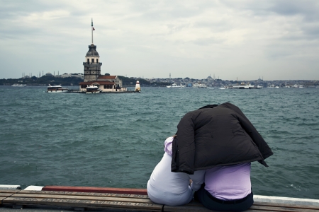 Istanbul, Uskudar, Turkey - September 09, 2011 - Couple watching The Maiden's Tower at Istanbul,Turkey. They are protecting theme selves from the rain by using the mans coat. Istanbul City and The Bosphorus at the picture too.のeditorial素材