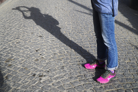 Istanbul, Turkey - October 16, 2016:New style pink nike shoes with jean at street on the cobblestone pavement. Also there is a photographers shadow.のeditorial素材