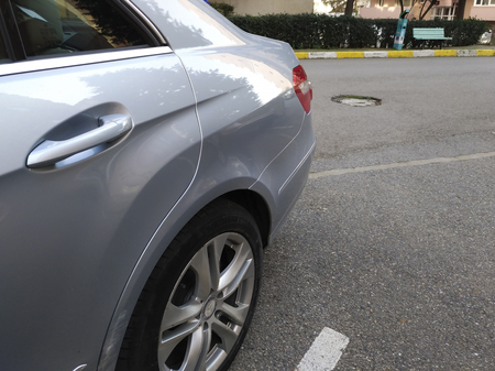 Istanbul, Turkey - February 18, 2018: Back door and tire detail of a parked Mercedes-Benz E250 at street of Istanbul.There are scratches on the door, left side of the tire.のeditorial素材