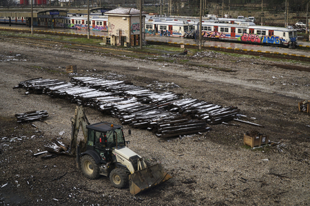 Istanbul, Turkey - March 1, 2018 : A parked buldozer is waiting for working hour. There is a major restoration at the railroad tracks. Old lumbers covered with snow and trains covered with graffitiのeditorial素材