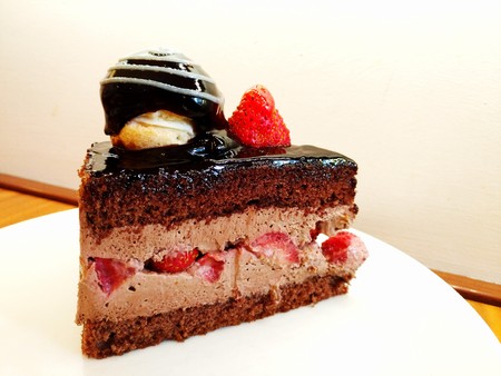 Slice of chocolate and strawberry cake in a dishの写真素材