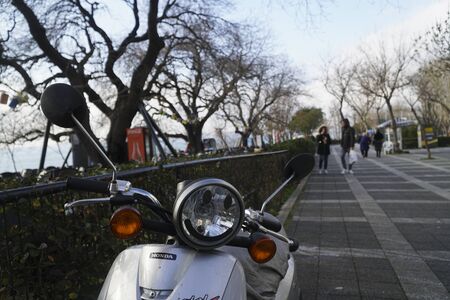Istanbul, Turkey - February 16, 2019 : There is a Honda motor scooter with a smiling face on the headlight at The Istanbul, Moda District with beautiful trees and people.のeditorial素材