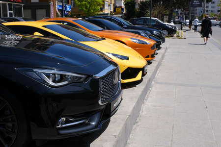 Istanbul, Turkey - April 29, 2021: Luxury sports cars on sale, like Infiniti, Lamborghini, Aston Martin, Mercedes Benz, Porsche are together at a street of Kadikoy, Istanbul. People are also walking in street.のeditorial素材