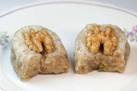 Delicious closeup walnut baklava on a white dish and ready to eatの写真素材