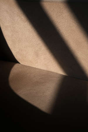 Shadowy abstract fabric detail of an armchair. Vertical beige fabric or textile detail as background.の写真素材