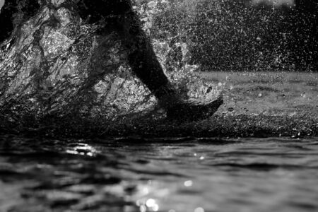 boy splashes water with his feetの写真素材