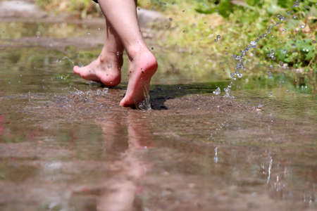 Boy runs on water splashing legsのeditorial素材