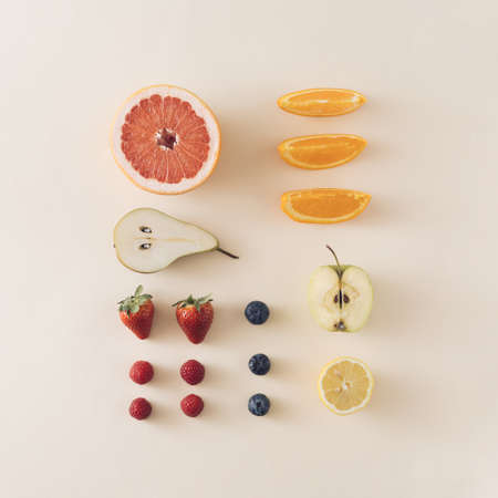 Neatly arranged summer fresh fruits on sandy color background.Minimal flat lay.の写真素材