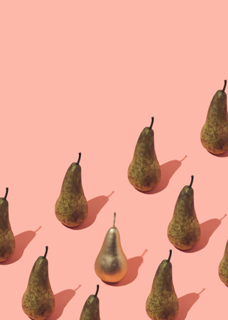 Pattern made of pears with one golden pear.On pastel pink background.Creative fruit food photography...