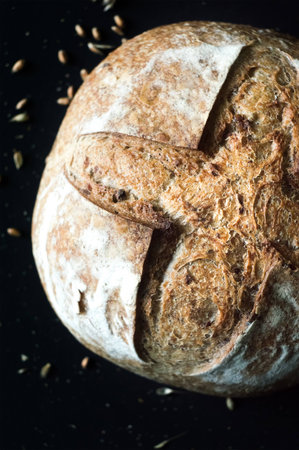 Close-up of crusty artisan bread with olives on black background, top viewの写真素材