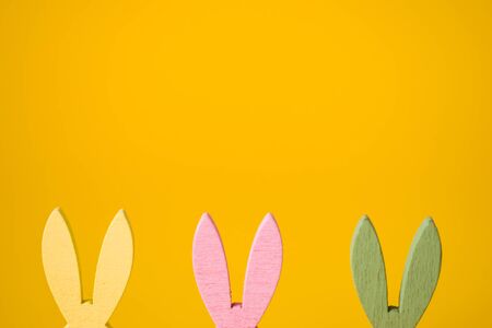 Easter bunny yellow, pink, green ears on yellow background