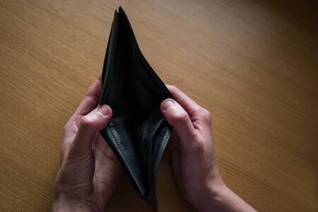 Close up hands holding empty black wallet